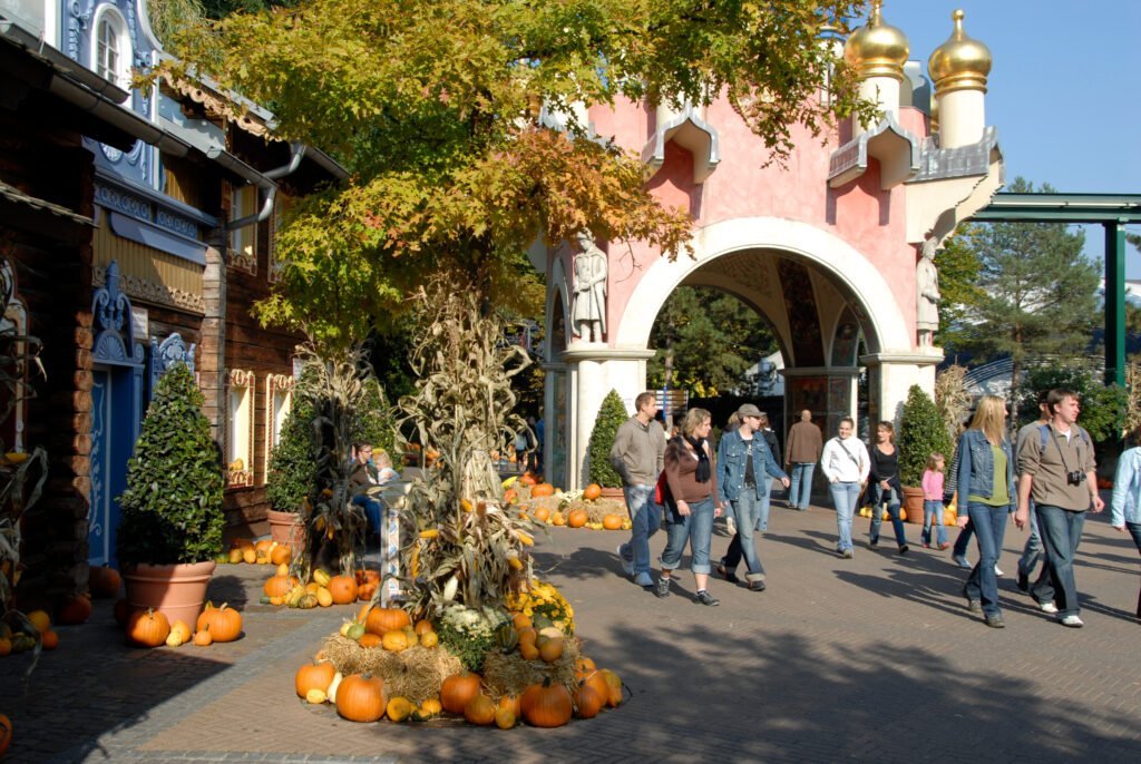 De poort van het Russische themagebied met op de voorgrond een gedecoreerde boom waar strobalen en pompoenen onder liggen tijdens Halloween in Europa-Park.